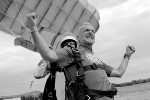homme à l'atterissage d'un saut en parachute en PACA les bras en l'air avec la voile de parachute gonflée photo en noir et blanc